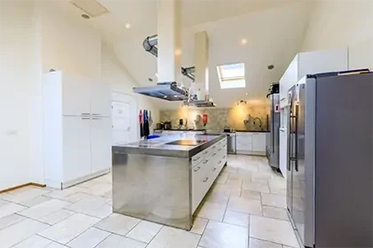 meerlo-keuken Lichte keuken van Connection SGGZ in Meerlo, met een kookeiland en kasten langs de wand.
