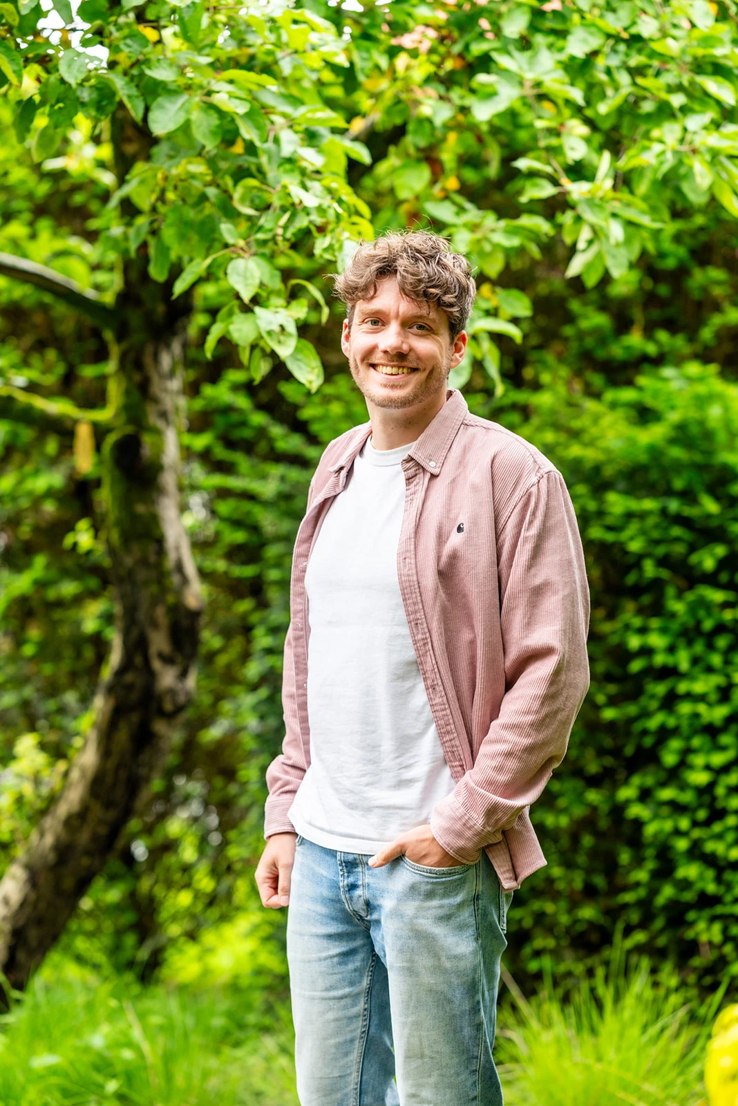 Jacob, lid van het team van Connection SGGZ, staat vriendelijk lachend in een groene omgeving.