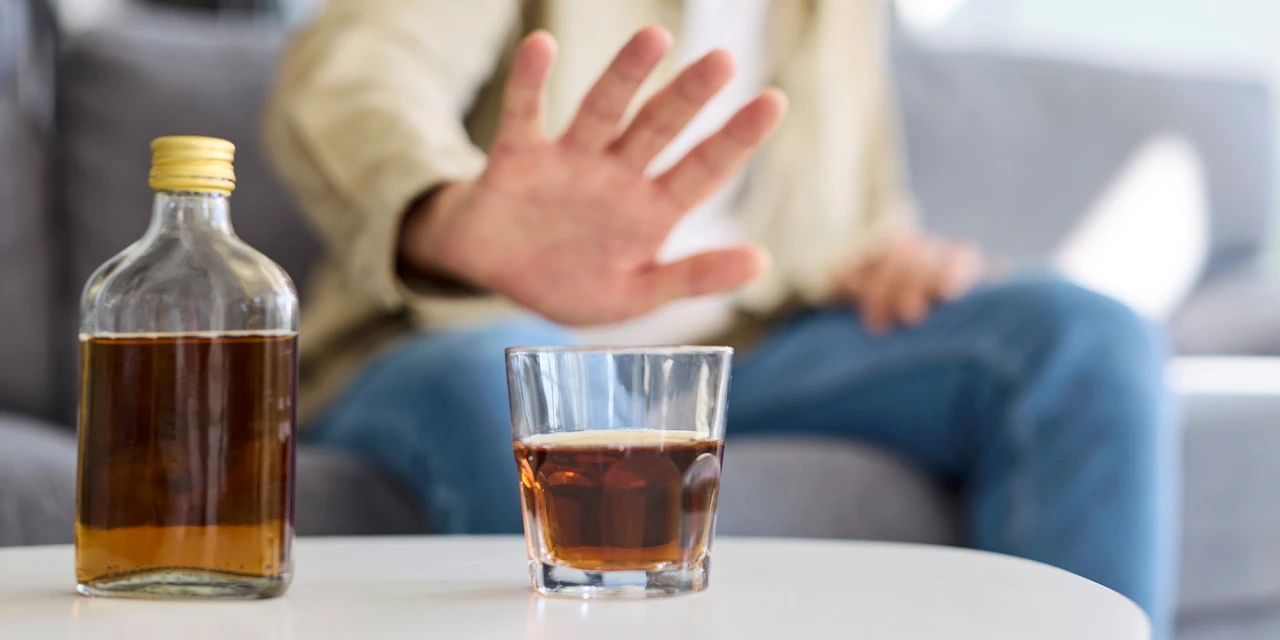 Persoon weigert glas alcohol; beeld dat past bij symptomen alcoholverslaving