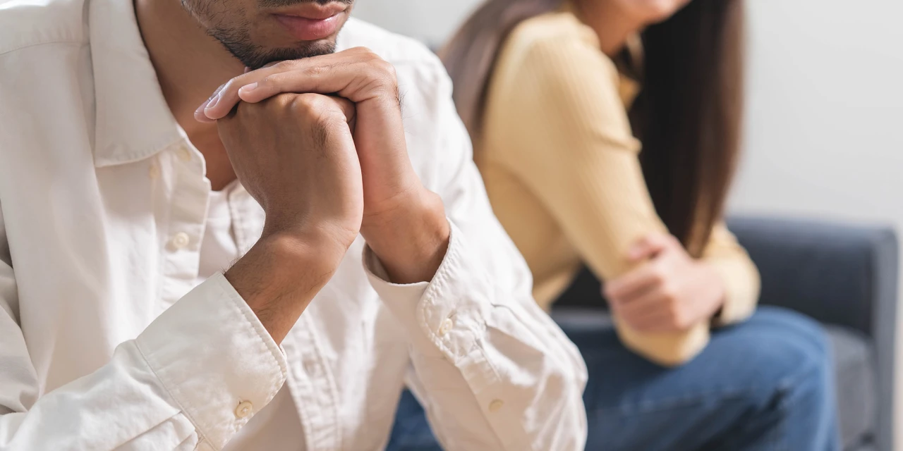 Man en vrouw zwijgend uit elkaar in relatie met een cokegebruiker op de bank.