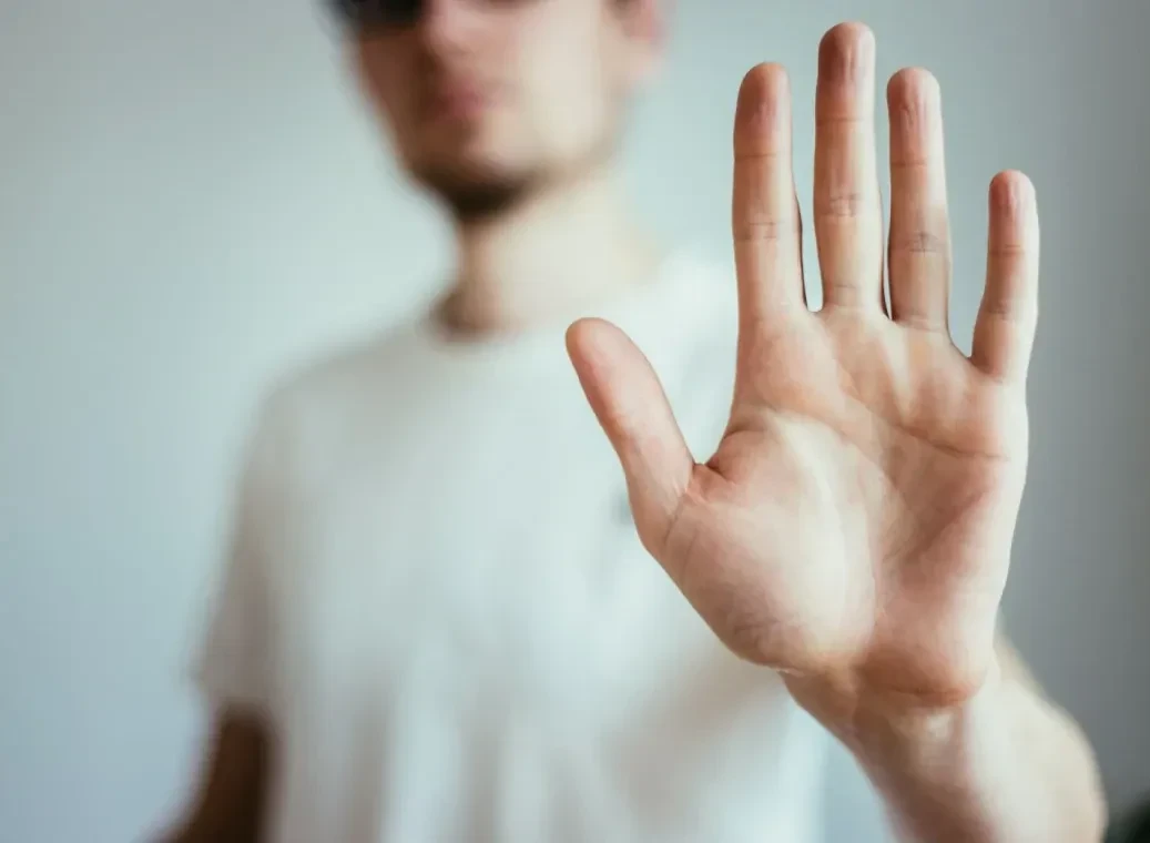 hand-gebaart-om-te-stoppen Man met wit T-shirt gebaart met hand om te stoppen met coke.