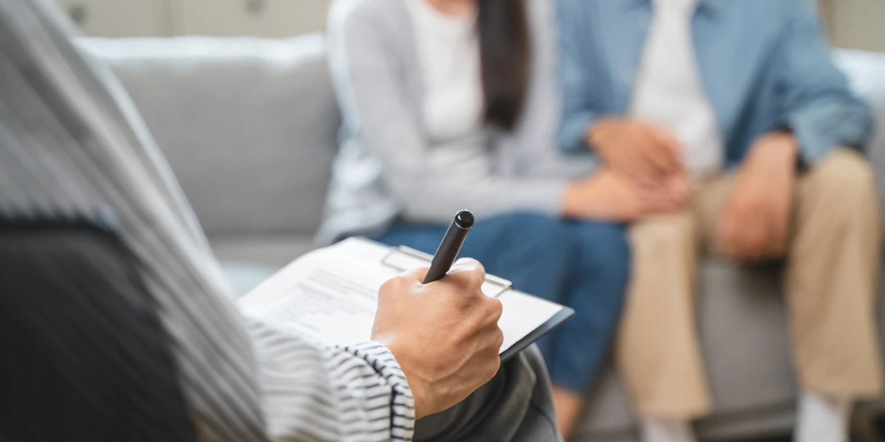 Erkende opleidingsinstelling gesprek met behandelaar en deelnemers terwijl notities worden gemaakt.
