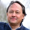 Gavin, teamlid van Connection SGGZ, leunt ontspannen tegen een boom.
