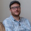 Wesley, met pet, bril en baardje, vertelt zijn herstelverhaal terwijl hij in een bruine stoel zit.