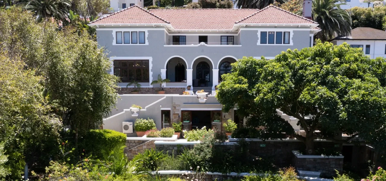 Afkickkliniek-in-Zuid-Afrika-buitenkant Buitenaanzicht van de afkickkliniek in Zuid-Afrika omringd door planten en bomen.